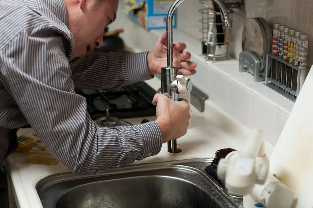 Fluid Plumbing & Heating technician repairing a kitchen faucet