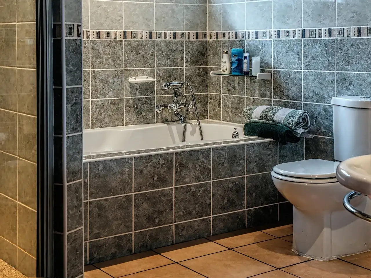 Tiled bathroom with bathtub and toilet